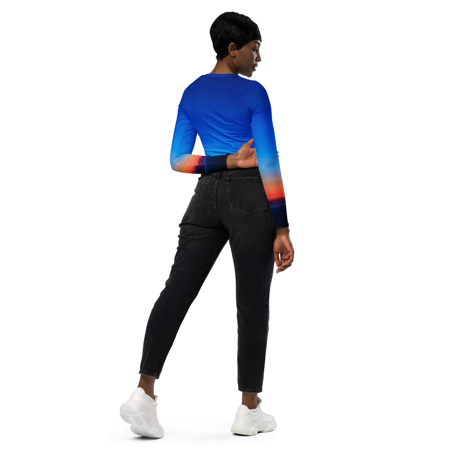 Back view of a woman wearing kallistii skyline long-sleeve crop top with blue and orange gradient design