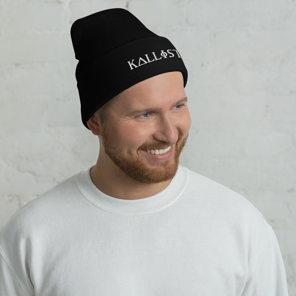 Smiling man wearing a black KALLISTII embroidered beanie with white logo and a white sweatshirt