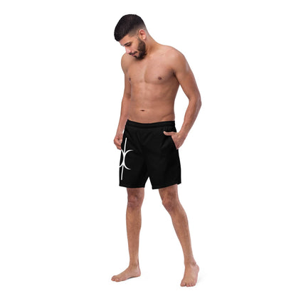 Men's black Hands of Eris swim trunks with white graphic design by kallistii modeled by a standing man