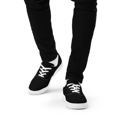 Black stylish low top shoes for men with white soles and laces worn with black pants