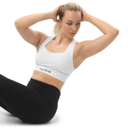 Woman wearing white KALLISTII activewear sports bra with black leggings posing in workout pose