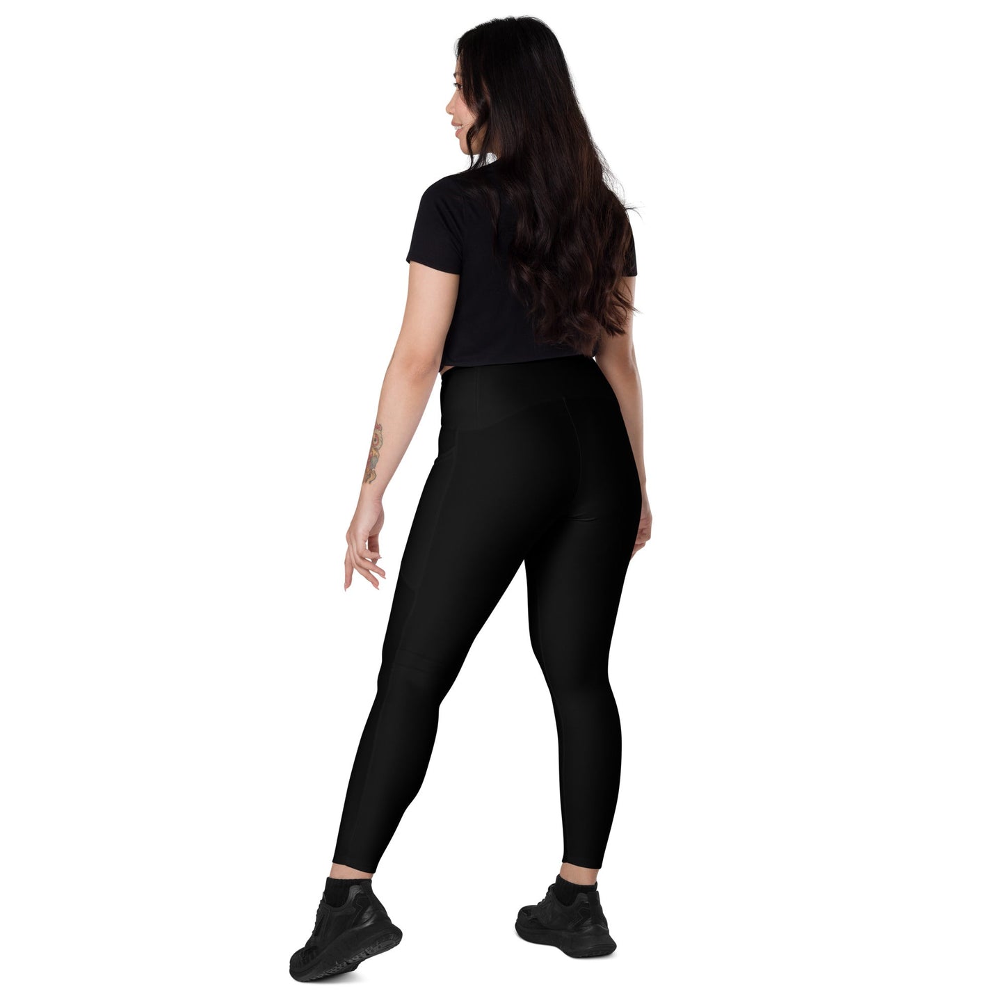 Woman wearing KALLISTII high waisted leggings in black with a fitted silhouette and black sneakers