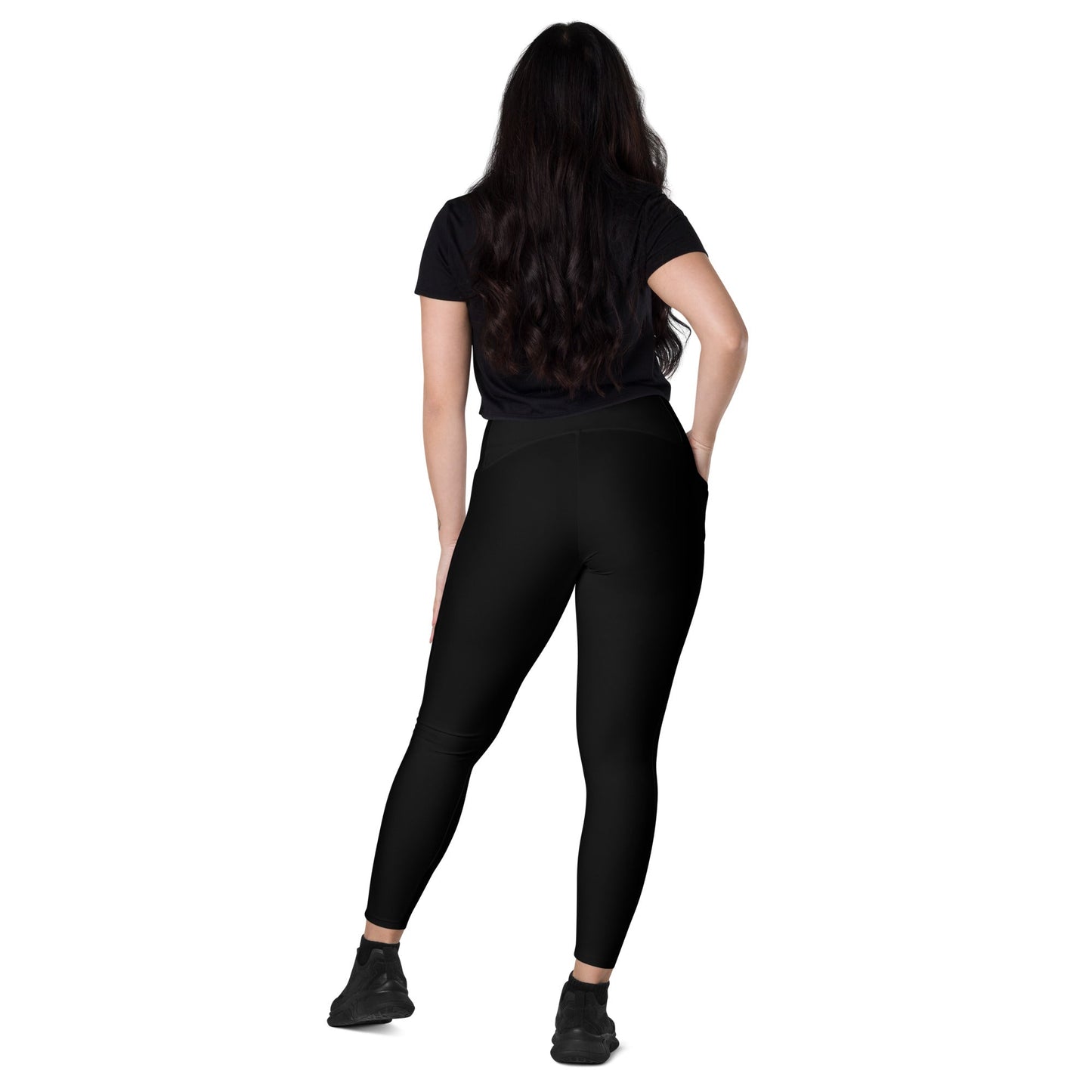 Woman wearing black KALLISTII high waisted leggings with short sleeve black top and black shoes standing with back view