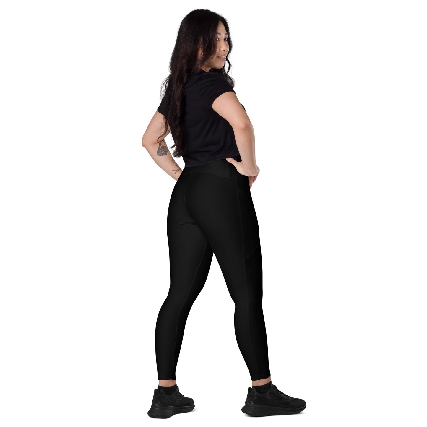 Woman wearing black KALLISTII high waisted leggings and black shirt standing in side pose