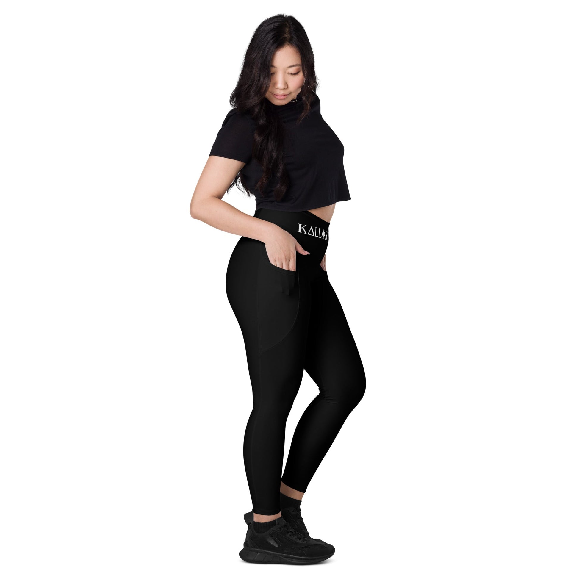 Woman wearing KALLISTII high waisted leggings in black with side pockets and black sneakers