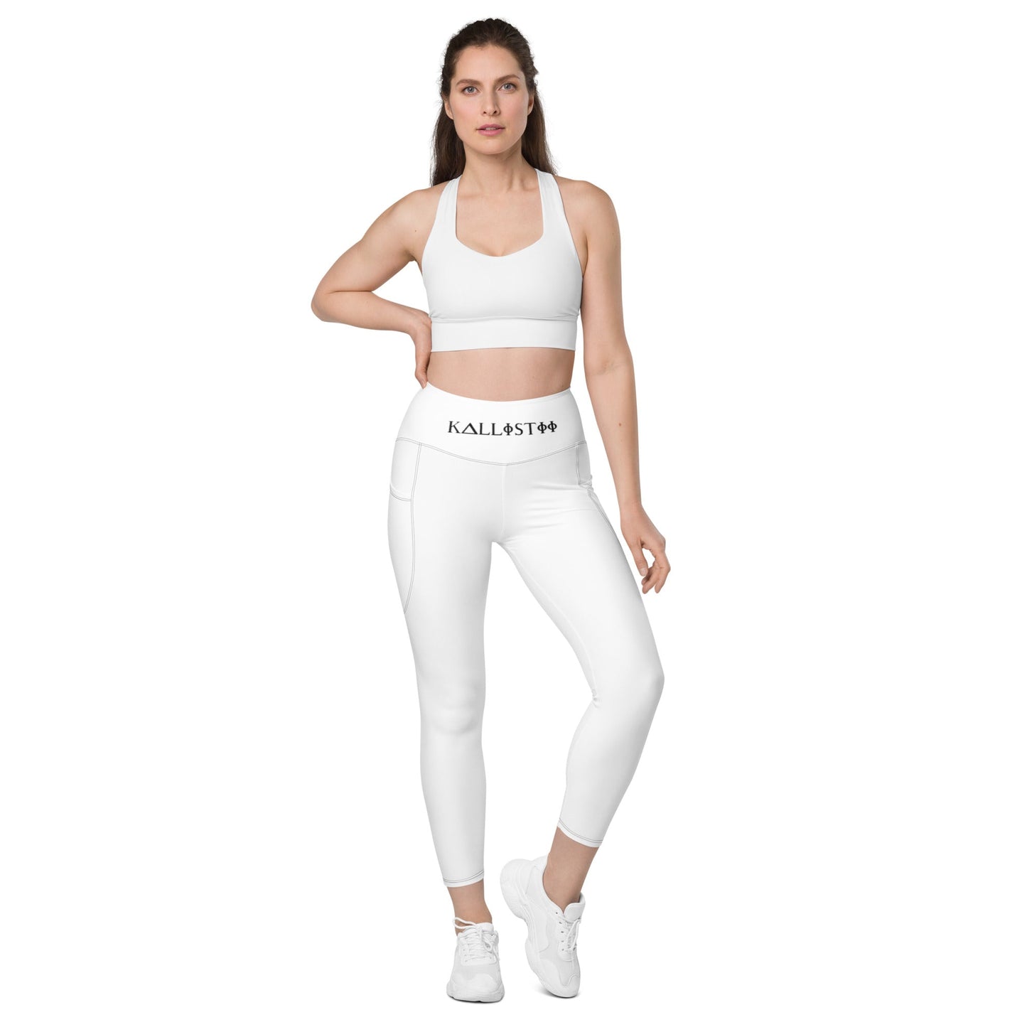 Woman wearing white KALLISTII high waisted leggings with side pockets and matching sports bra