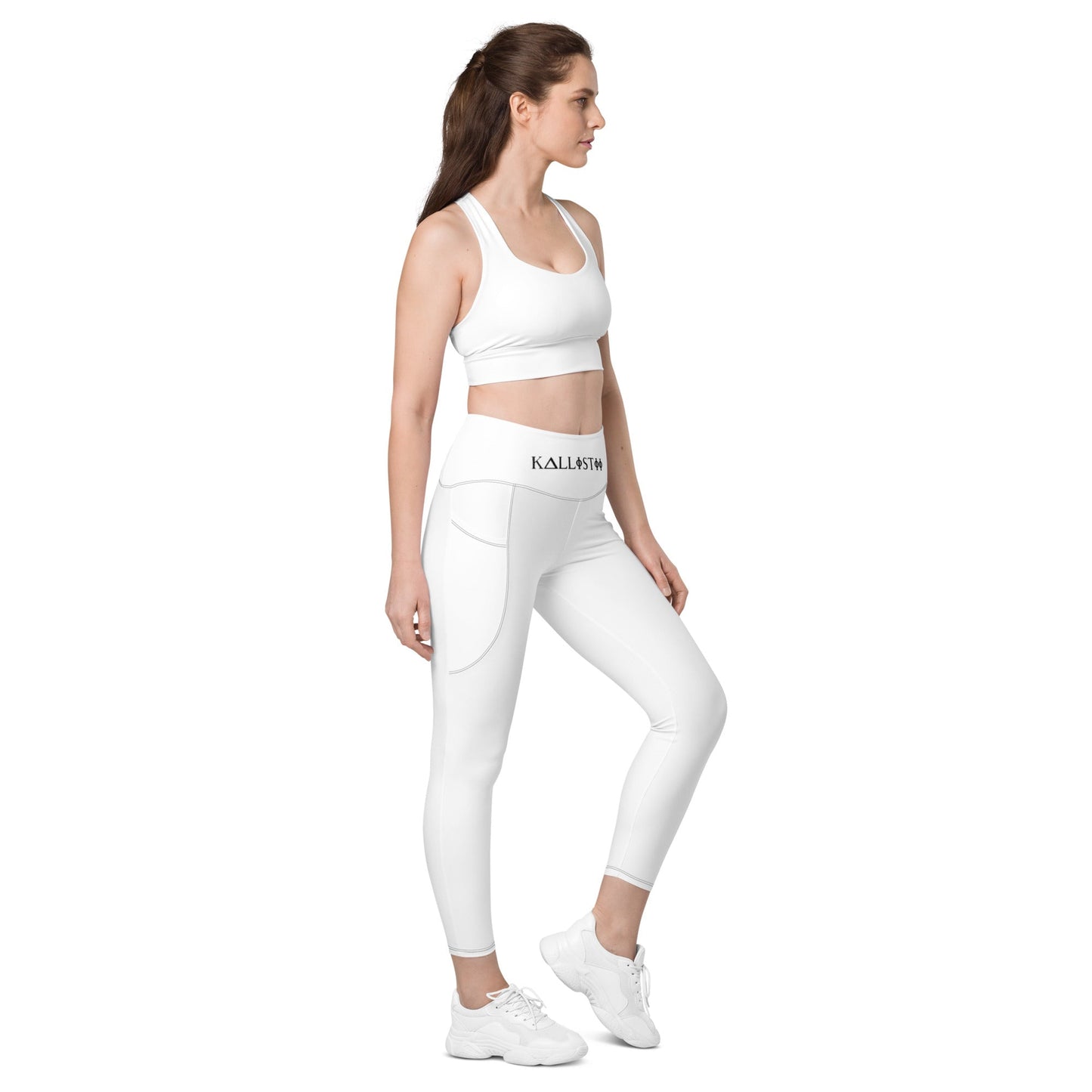 Woman wearing white KALLISTII high waisted leggings with side pockets and matching white sports bra