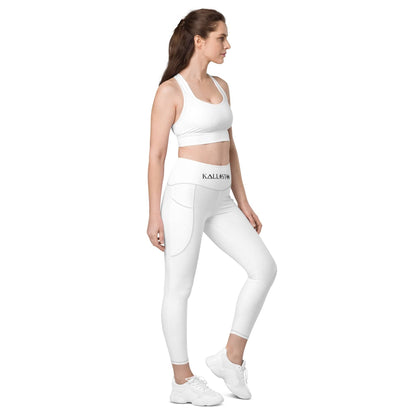 Woman wearing white KALLISTII high waisted leggings with side pockets and matching white sports bra