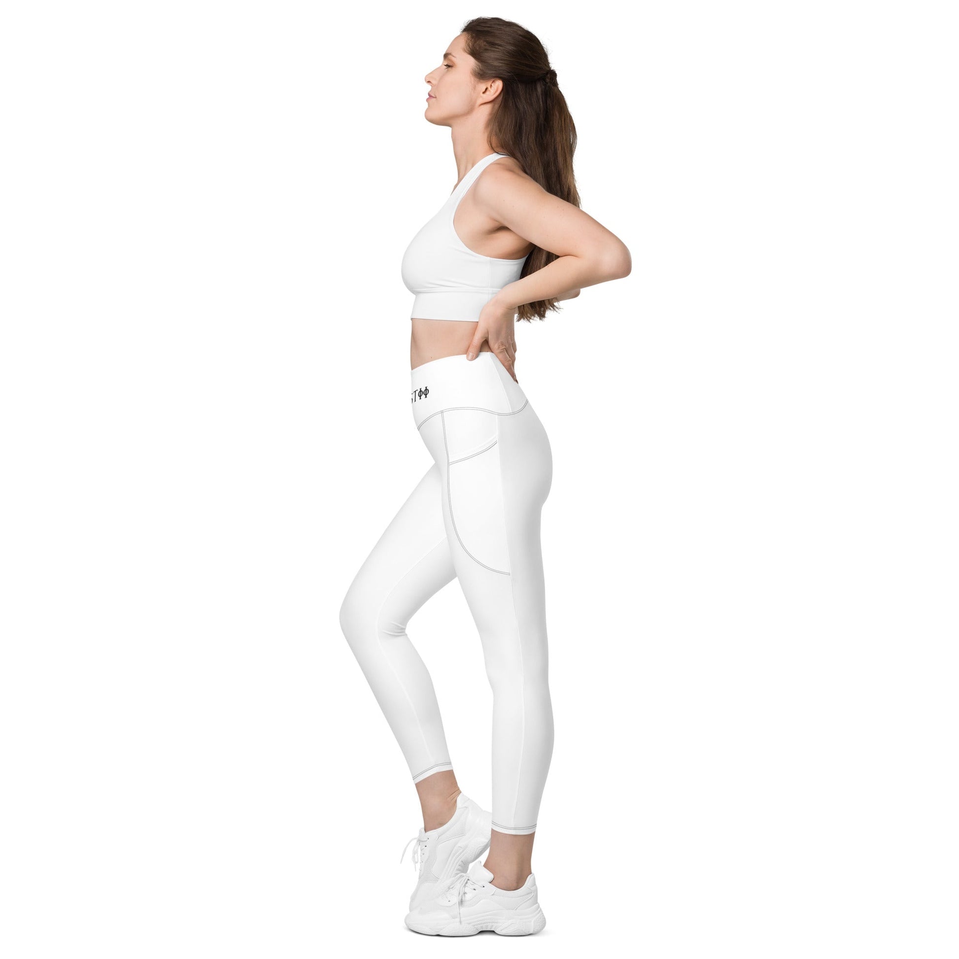 Woman wearing white KALLISTII high waisted leggings with side pockets and white workout sneakers