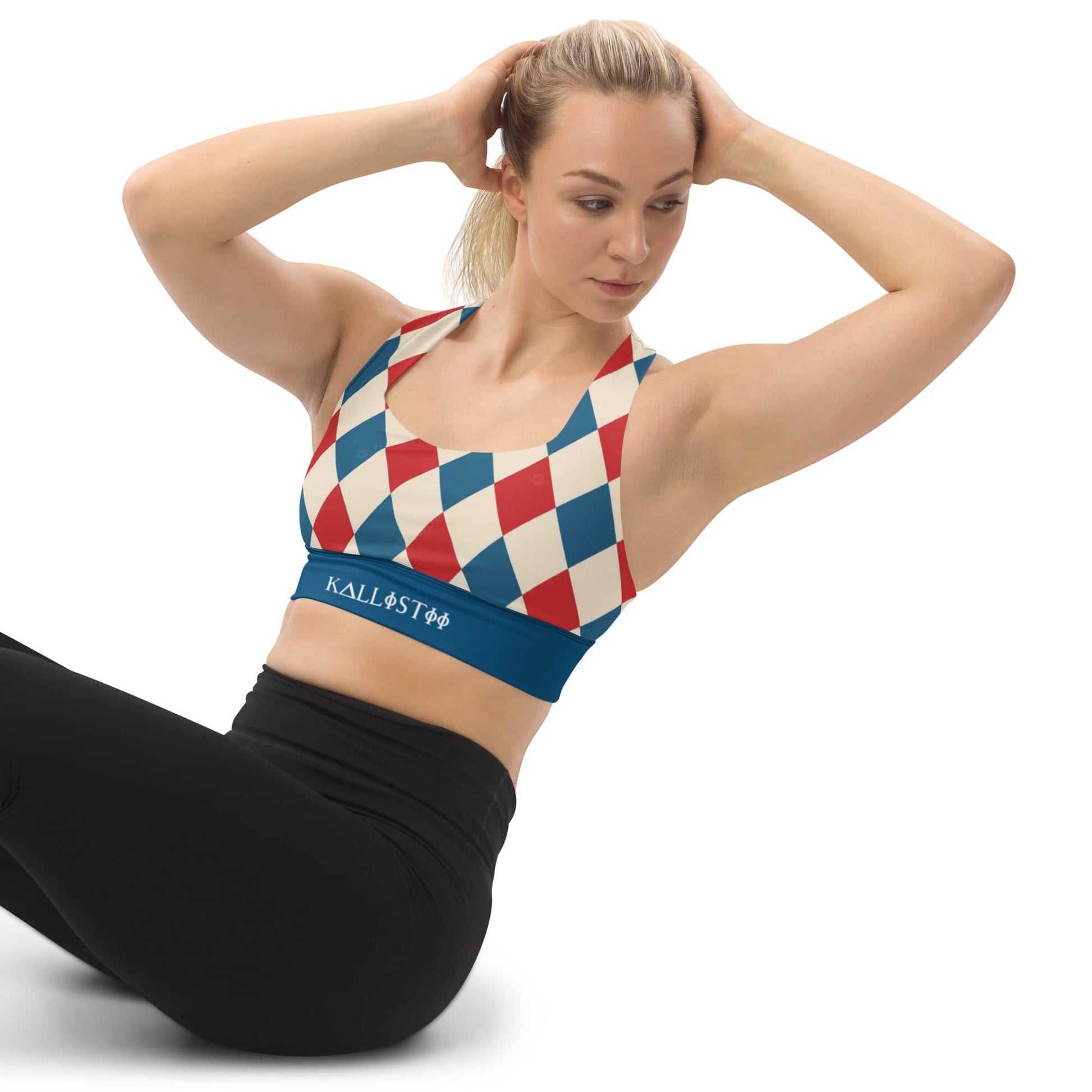 Woman wearing kallistii harlequin sports bra with red, blue, and cream diamond pattern while exercising
