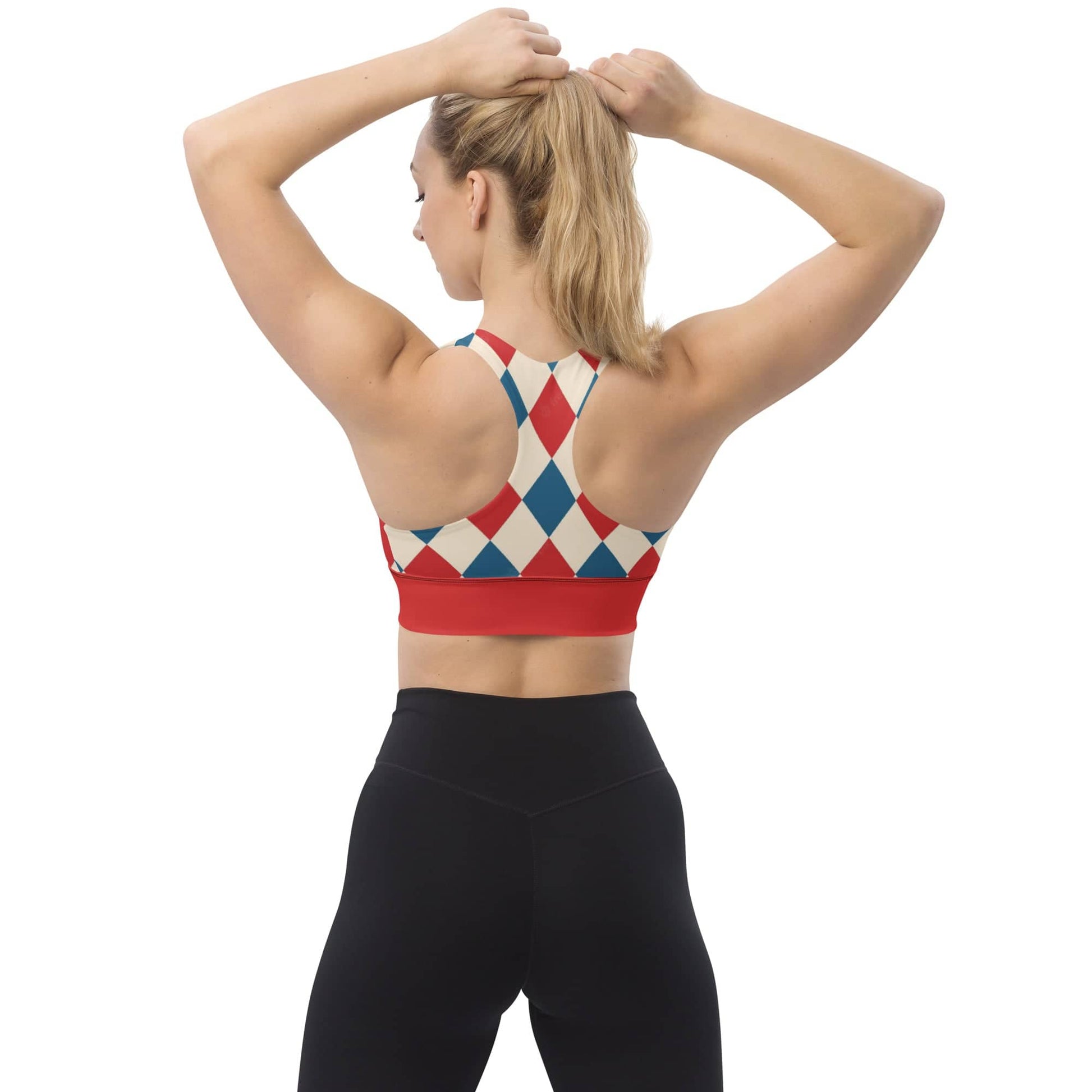 Back view of a woman wearing kallistii harlequin sports bra with red and blue diamond pattern and black leggings