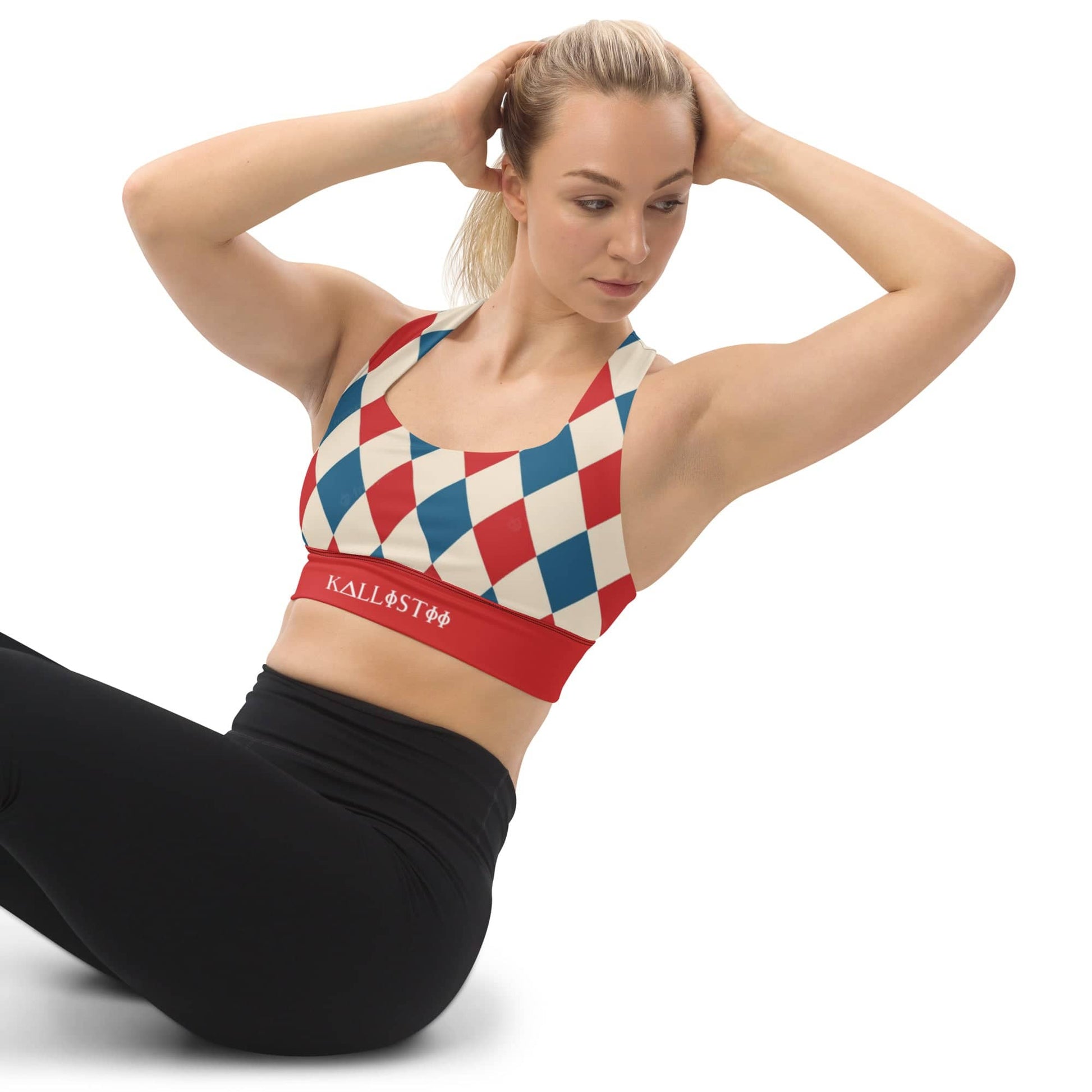 Woman wearing kallistii harlequin sports bra with red and blue diamond pattern and black leggings