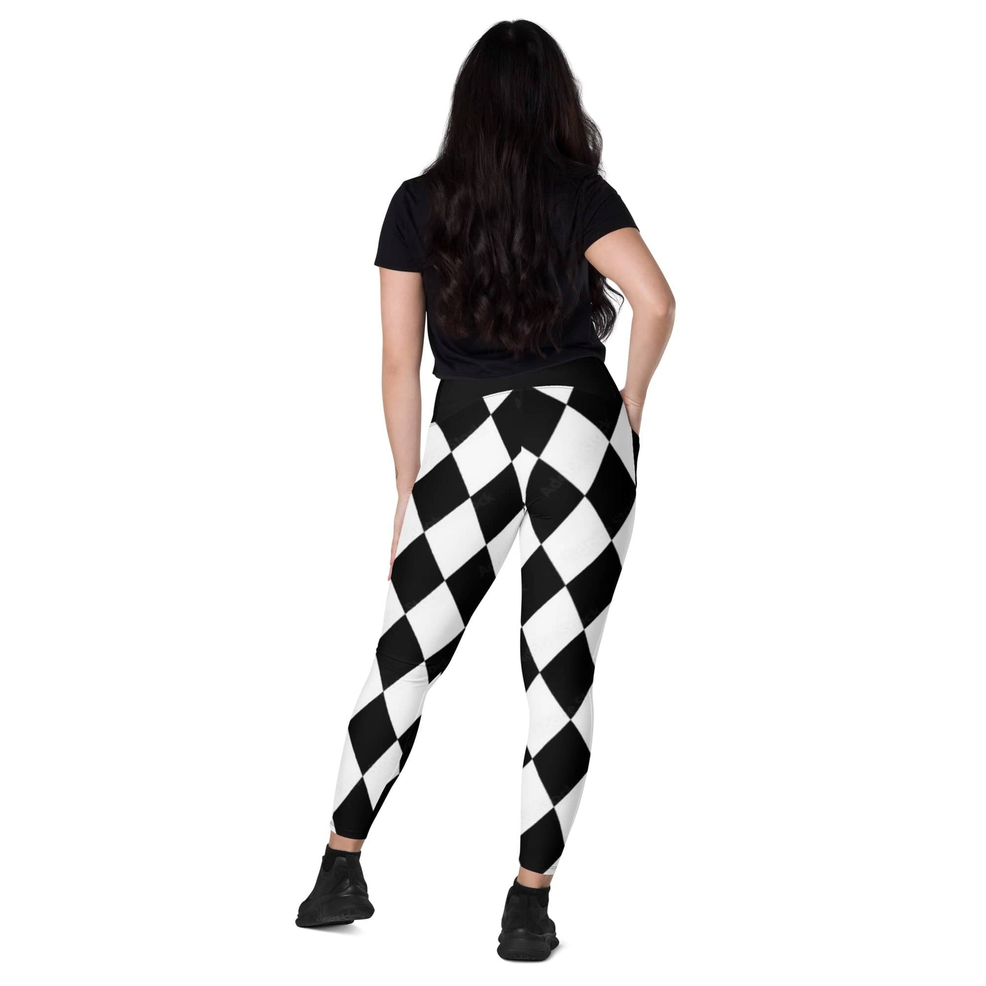 Woman wearing black and white harlequin leggings standing with back facing the camera