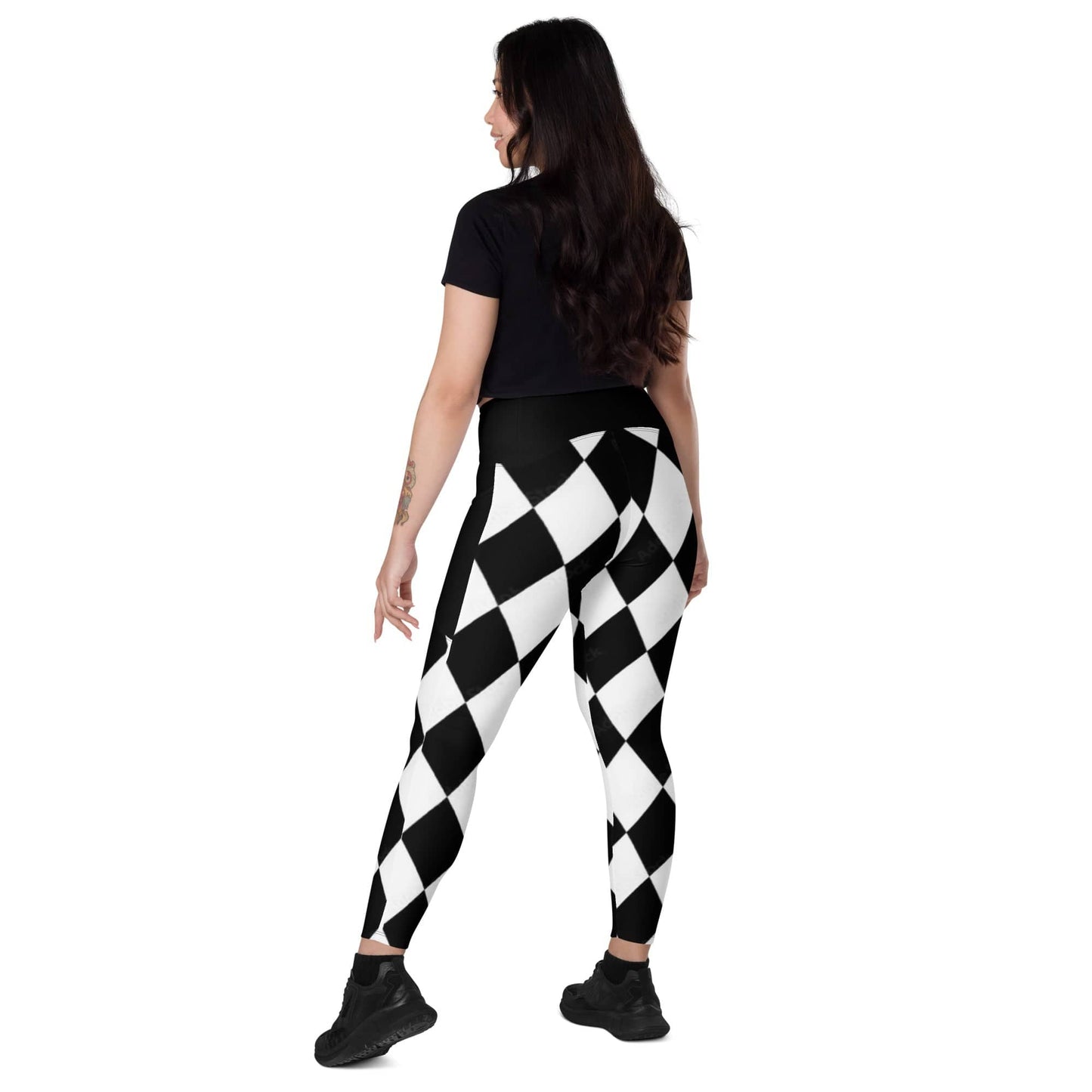 Woman wearing kallistii black and white harlequin leggings with geometric diamond pattern and black top