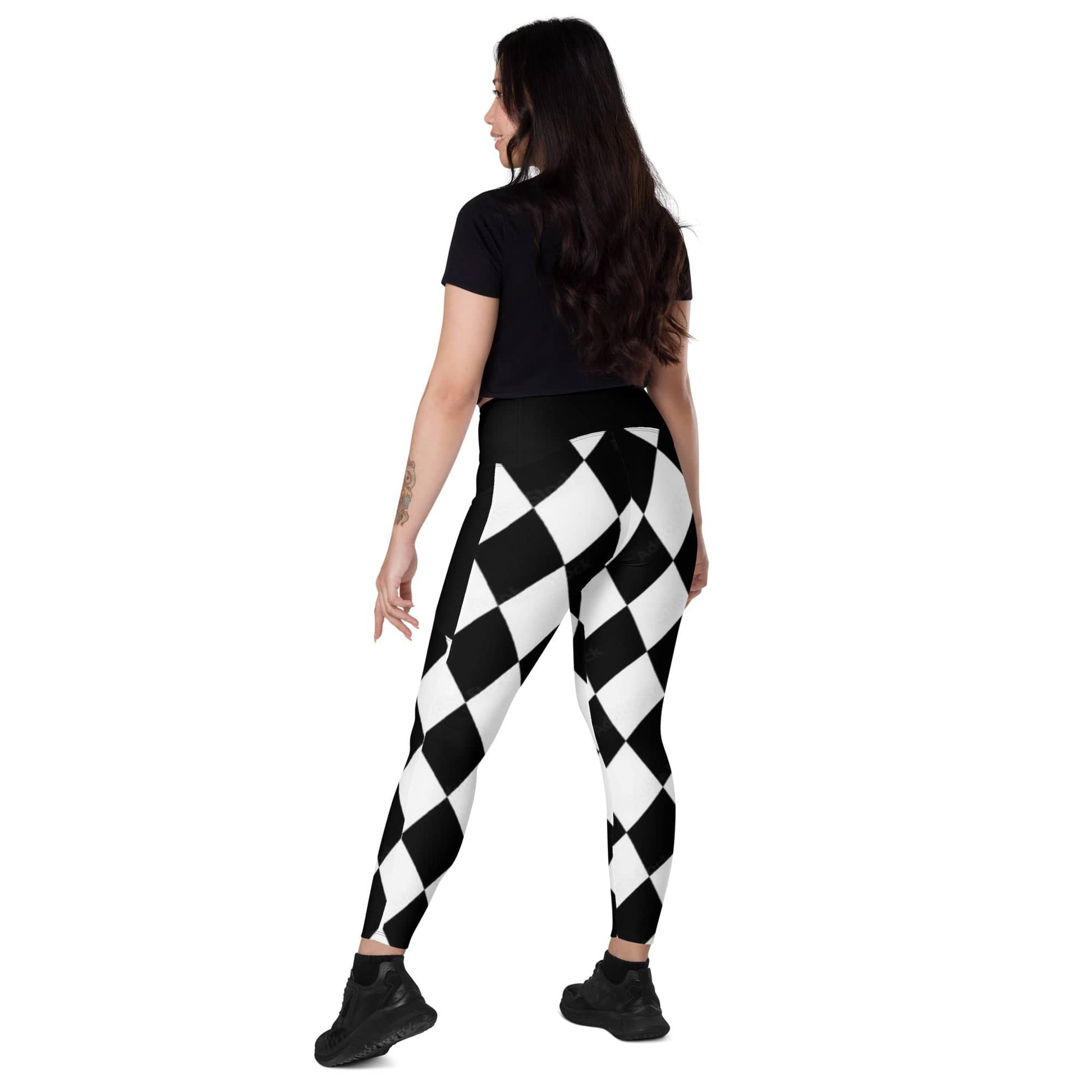 Woman wearing kallistii black and white harlequin leggings with geometric diamond pattern and black top