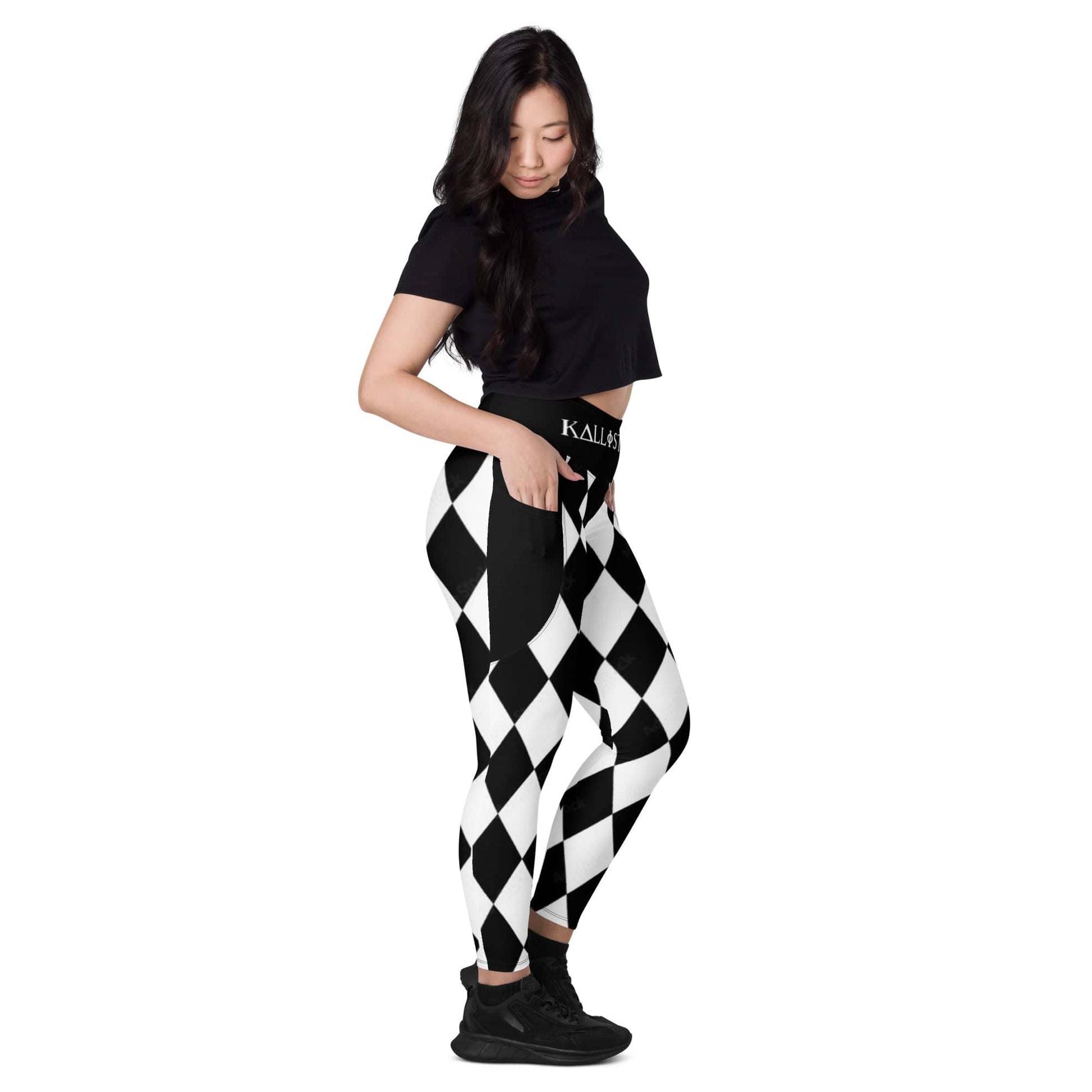 Woman wearing black and white harlequin leggings with pockets and black crop top
