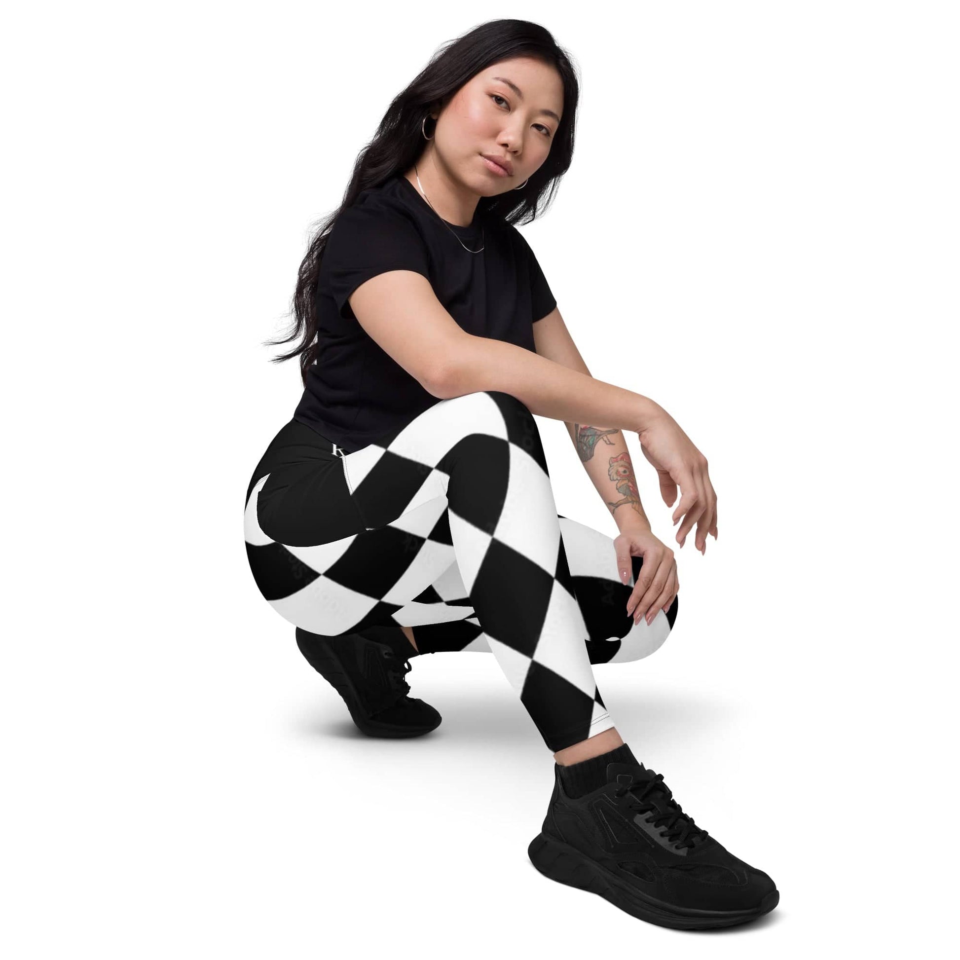 Woman wearing black and white harlequin leggings paired with black shirt and shoes