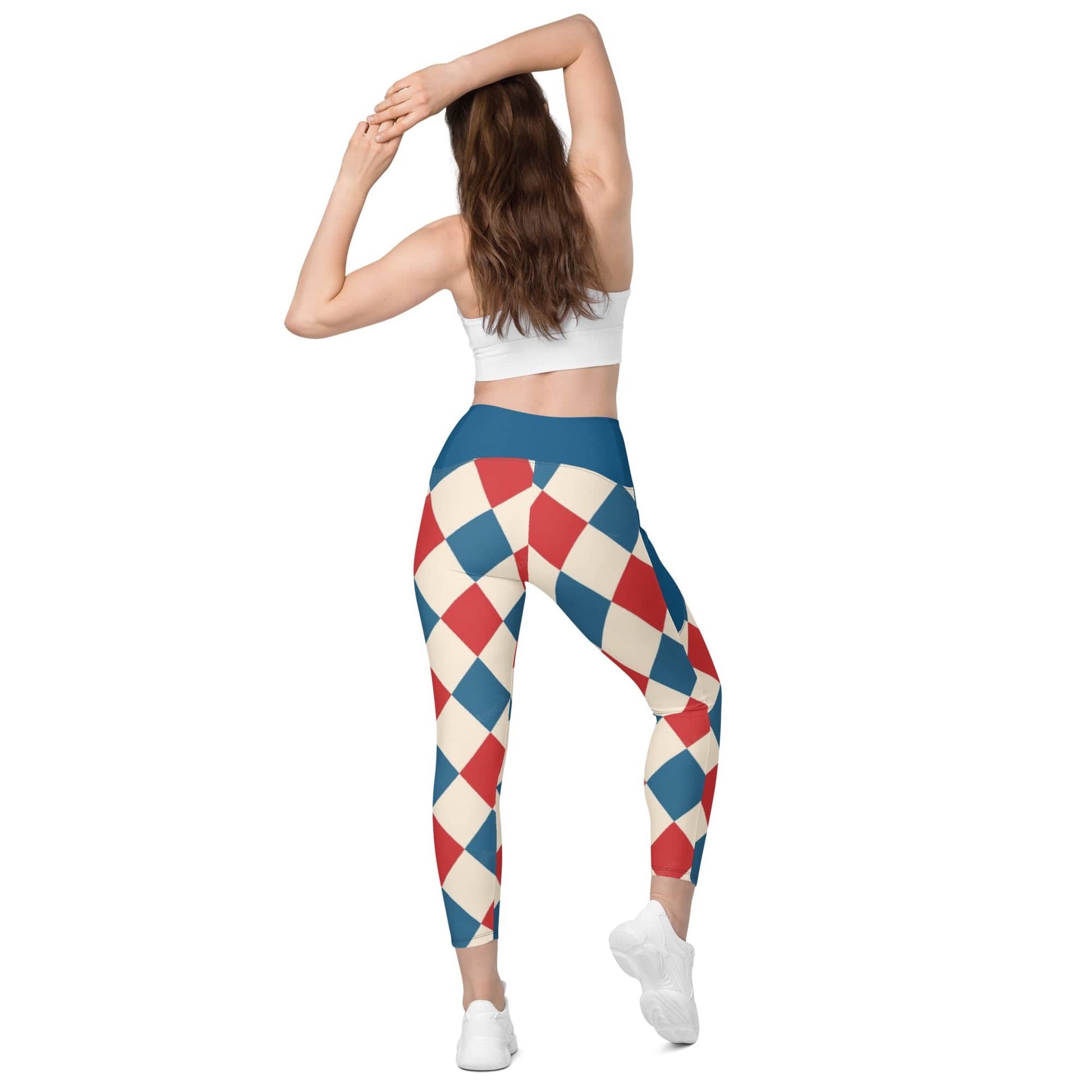 Woman wearing kallistii harlequin leggings with red blue and cream diamond pattern and blue waistband