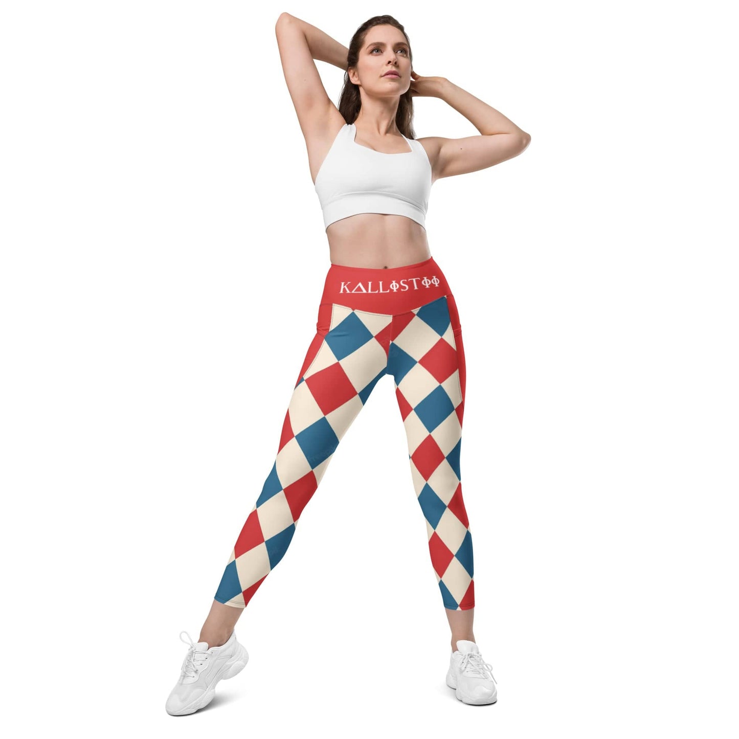 Woman wearing kallistii harlequin leggings with red, blue, and cream diamond pattern and white sports bra