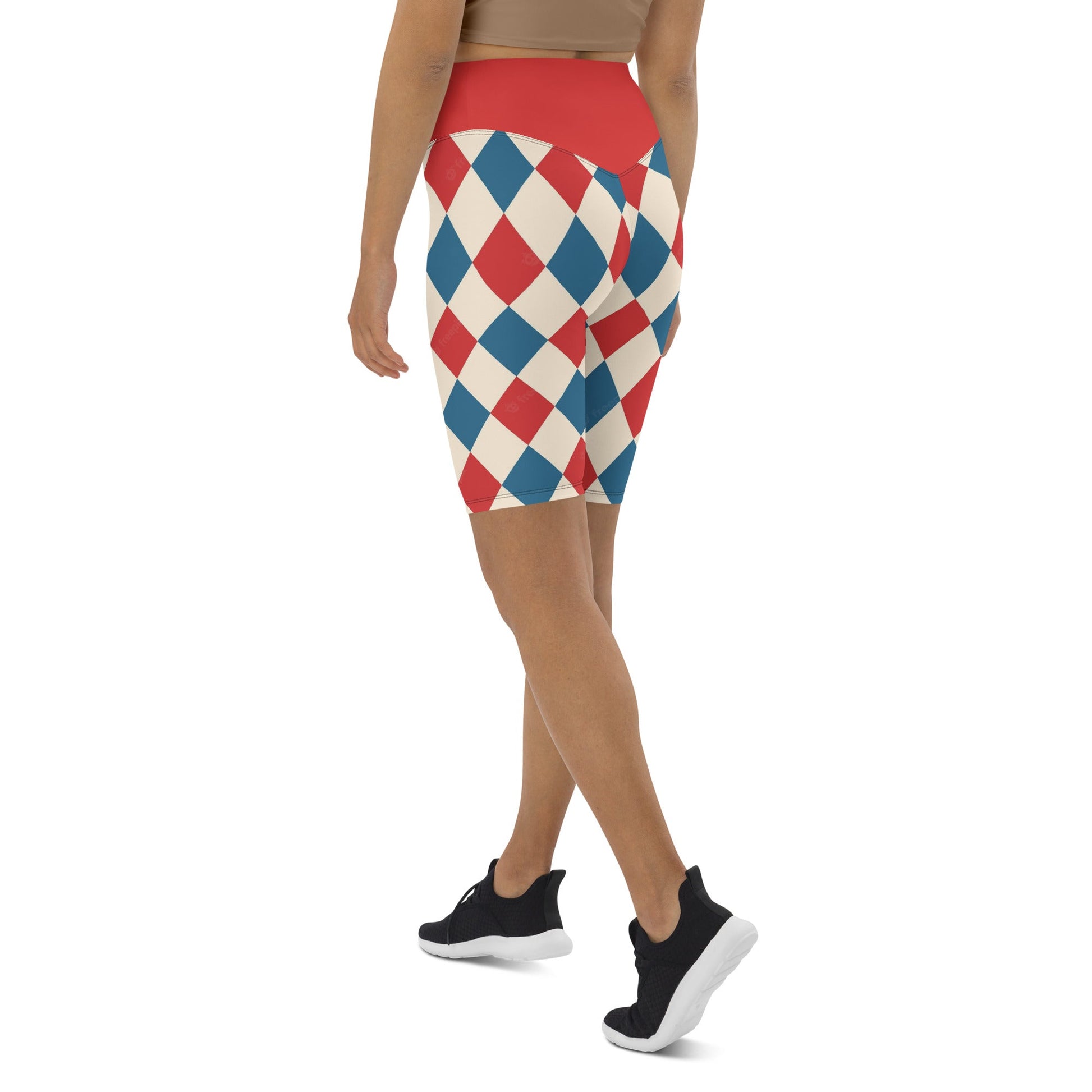 Kallistii harlequin active shorts in red blue and white diamond pattern worn by woman with black sneakers