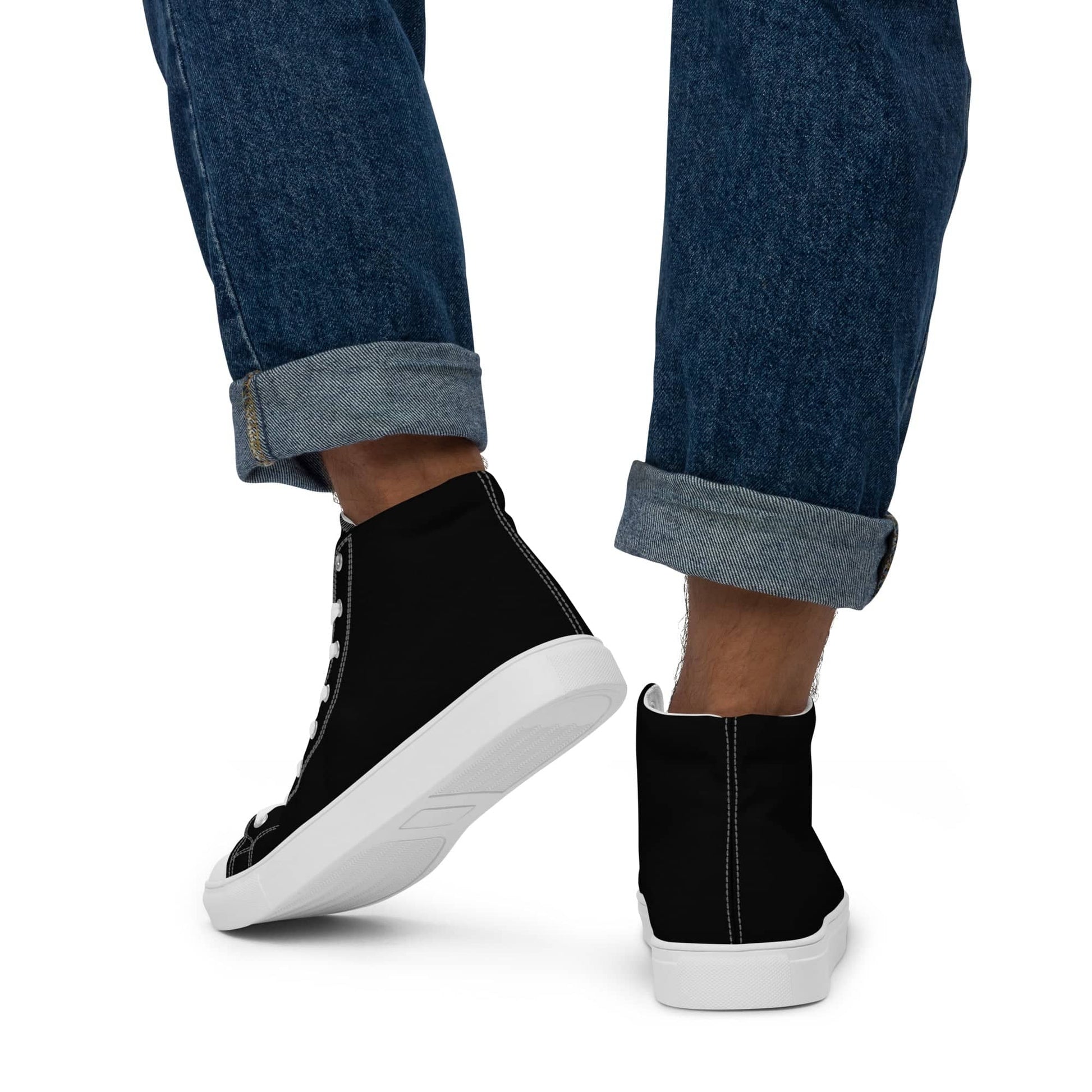 Black high-top statement sneakers for men worn with rolled-up denim jeans showing white soles and stitching details