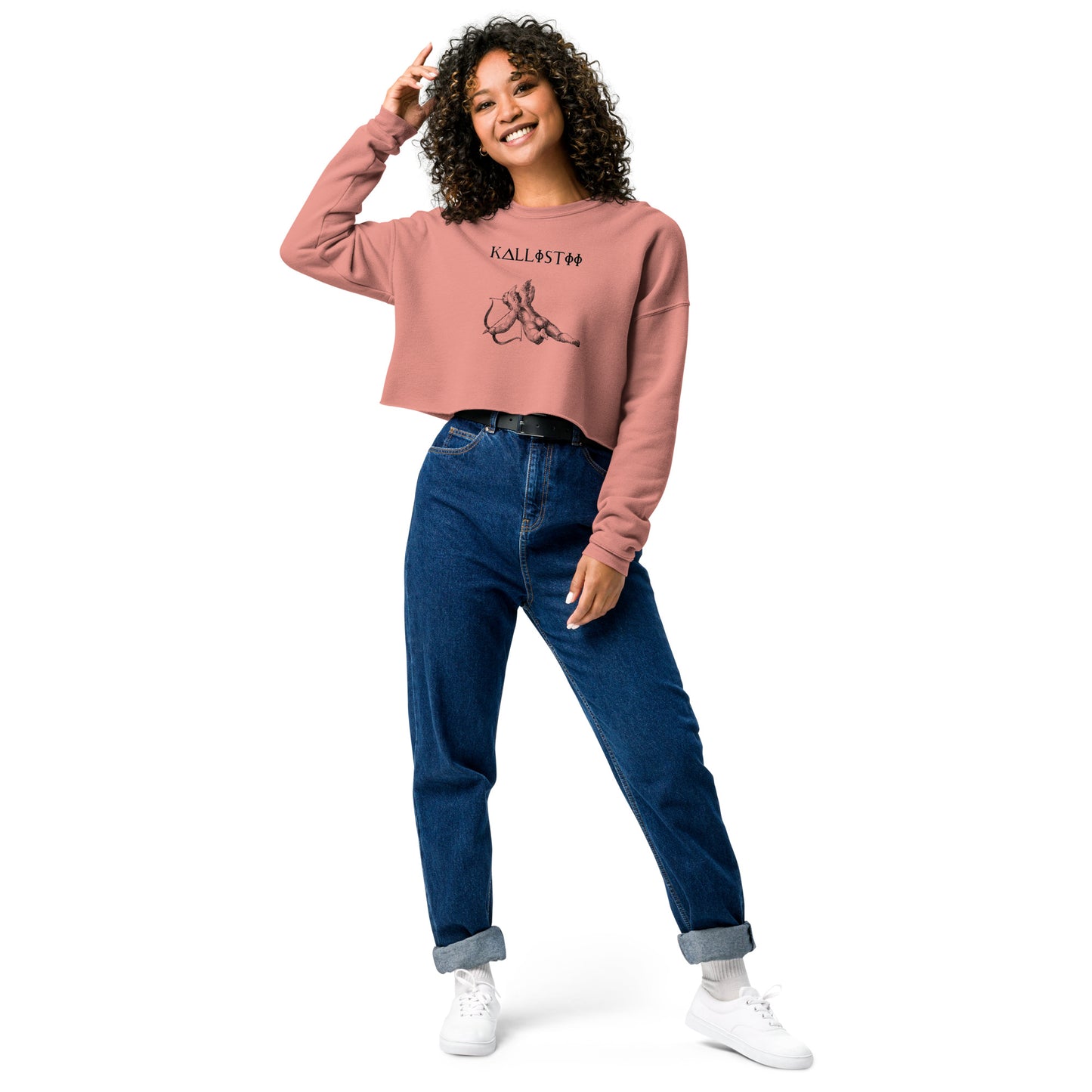 Woman wearing kallistii Eros crop sweatshirt in dusty pink paired with high-waisted blue jeans and white sneakers