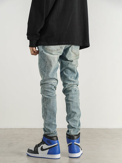Kallistii painted effect slim fit jeans worn with black top and blue high top sneakers