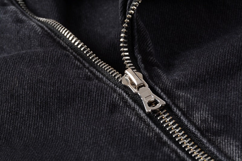 Close-up of silver zipper detail on black denim motorcycle jacket by kallistii