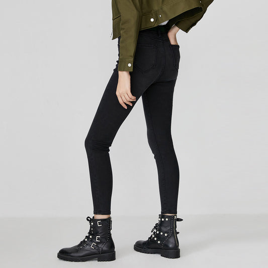 Woman wearing kallistii black fade skinny jeans paired with black studded combat boots and green jacket