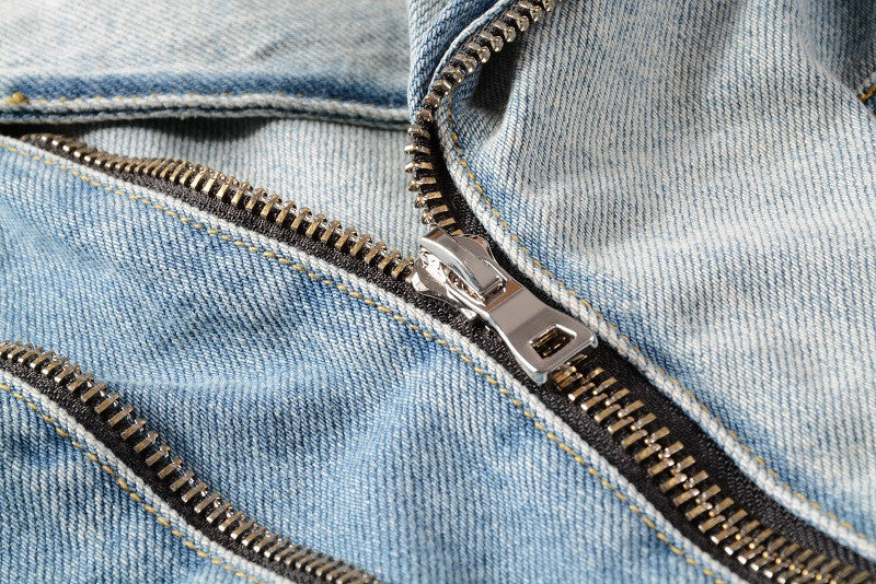 Close-up of metal zipper detail on blue denim motorcycle jacket by kallistii