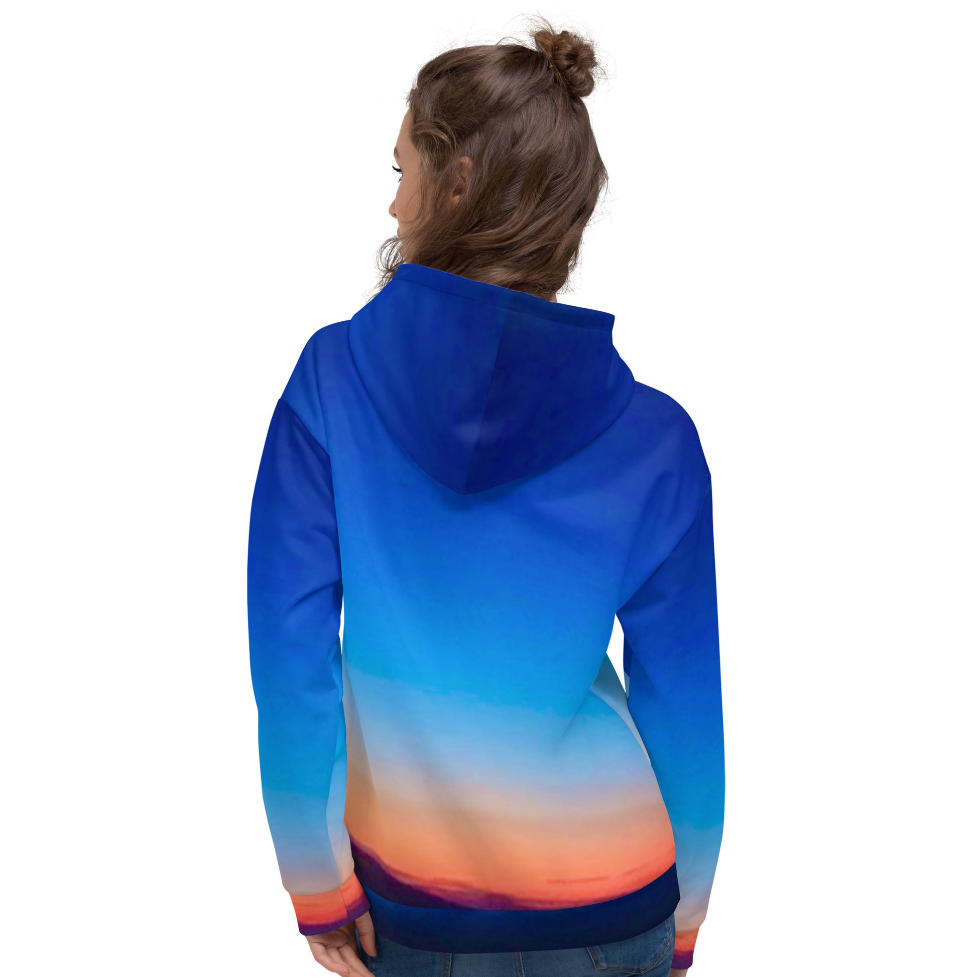 Back view of woman wearing kallistii skyline hoodie unisex with blue and orange sunset gradient design