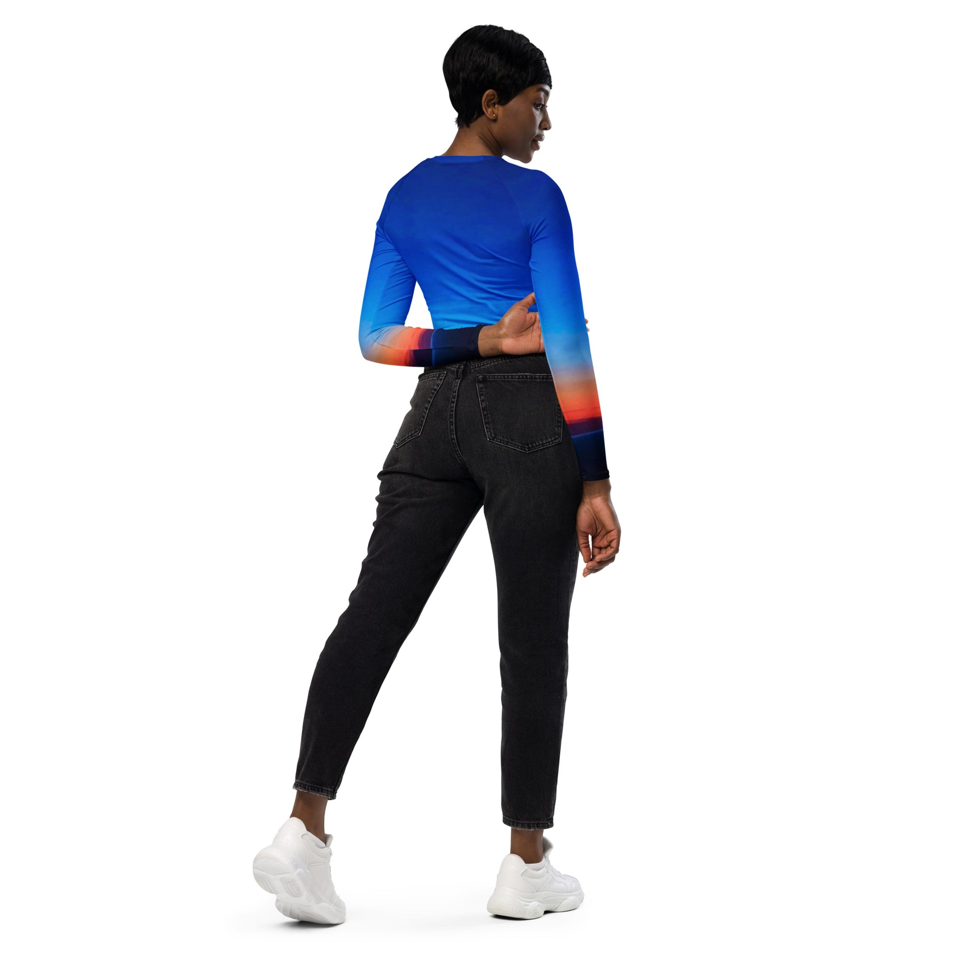 Back view of a woman wearing kallistii skyline long-sleeve crop top with blue and orange gradient design