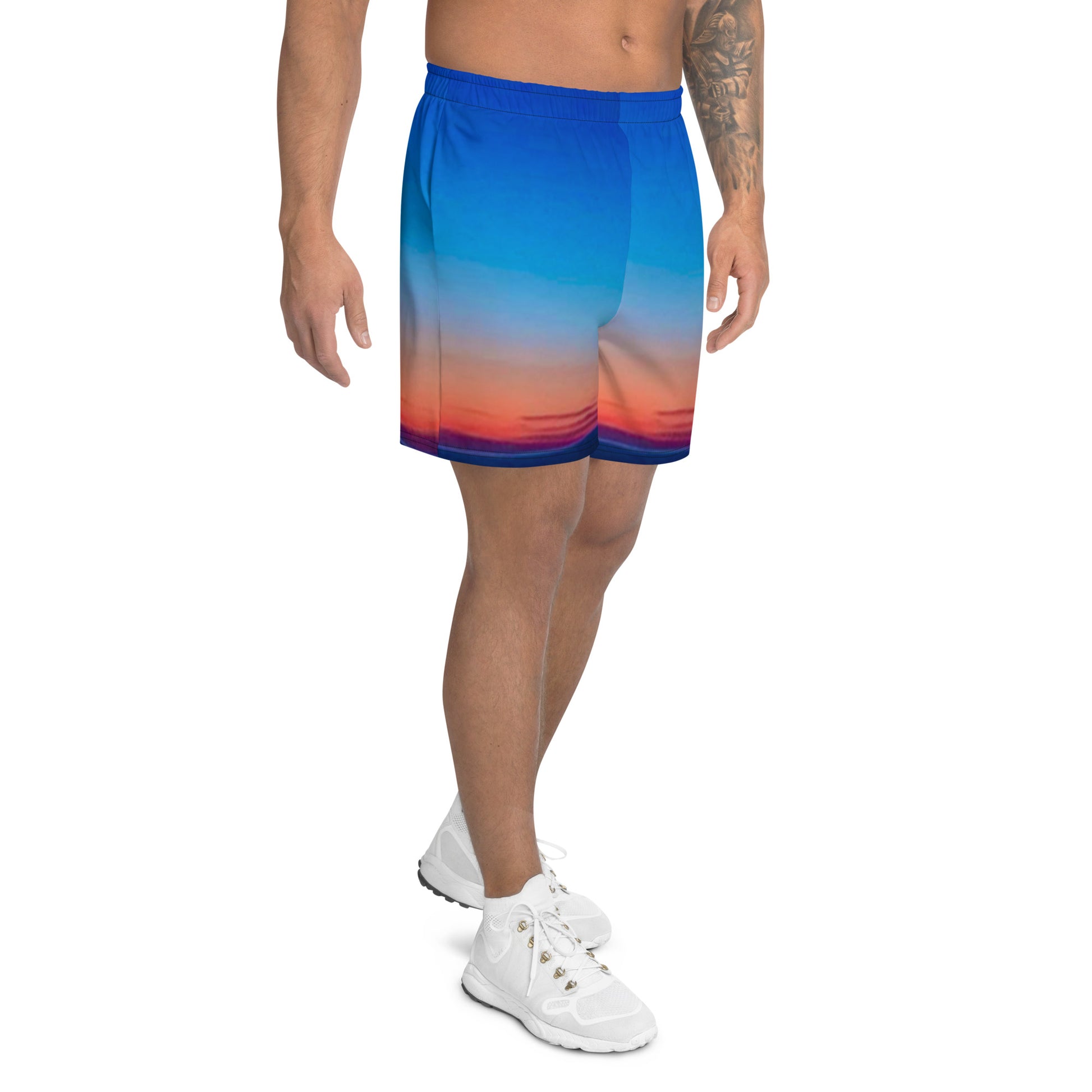 Kallistii skyline mens athletic shorts featuring a blue to orange gradient sunset design worn with white athletic shoes