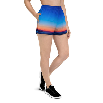 Kallistii skyline print running shorts featuring a blue and orange gradient sunset design with side pockets