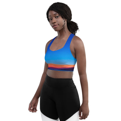 Woman wearing kallistii skyline sports bra with vibrant blue and sunset gradient design