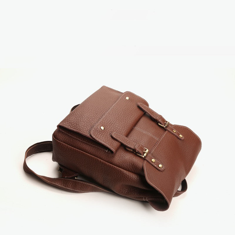 Brown leather backpack with buckle straps on a white background stylish black leather backpack